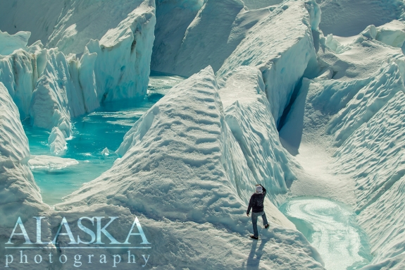 A man goes to get a closer look at the pools inside the glacier.