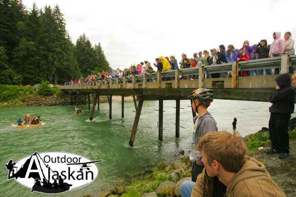 Spectators watch as rafts compete in the Mad Raft Race. An annual 4th of July tradition in Haines, where rafters float from Chilkoot Lake to the bridge that crosses the Chilkoot River.