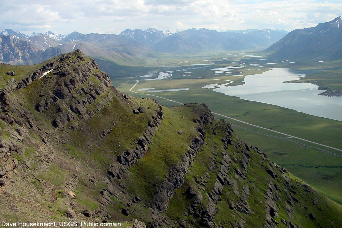 View southward from Fortress Mountain Formation on Atigun syncline towards Brooks Range.  Trans-Alaska Pipeline, haul road, and Galbraith Lake in valley.  Location in Brooks Range foothills, about 90 miles southeast of Umiat. Dave Houseknecht, USGS. Public domain