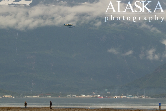 A Piper PA-14 flies over Port Valdez.