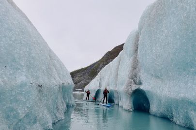 Having a good time paddleboarding between icebergs.