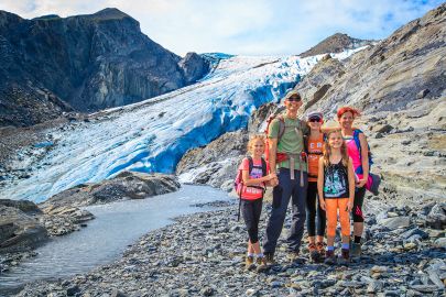 A family stands out in front of Worthington Glacier on the hike out to it.