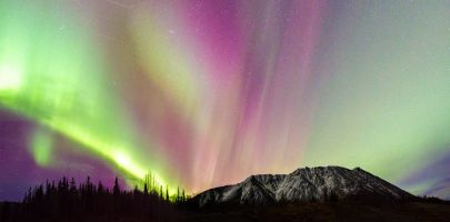 The sky fills with color while chasing the aurora borealis in the Yukon.