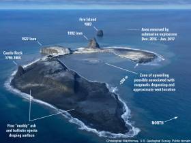 Bogoslof Island showing the cumulative effects of 2016-17 eruptive activity. A layer of fine muddy appearing ash drapes most of the landscape and covers pre-existing vegetation. The dashed line indicates the area excavated by explosive eruptive activity so far. A prominent zone of upwelling is probably the surface expression of a shallow submarine vent. Photograph taken by Dan Leary, Maritime Helicopters, January 10, 2017.