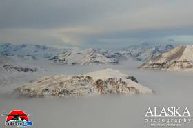 Inside Wrangell-Saint Elias National Park, Gold Hill rises above the fog, with Mount Sanford in the distance and Mount Jarvis on the left.