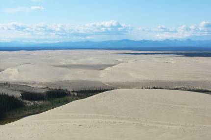 An aerial view of the Great Kobuk Sand Dunes in a designated wilderness area with the Baird Mountains on the horizon. Image rights: public domain; NPS